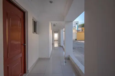 an empty hallway of a building with a door at Sunset Single Room Near Airport Wi-Fi & Parking in La Viva