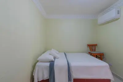 a room with a bed with two pillows on it at Sunset Single Room Near Airport Wi-Fi & Parking in La Viva