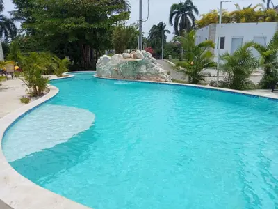 a large blue swimming pool with a water fountain at Studio Residencial Almendra in Cabarete
