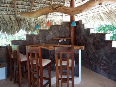 a bar in a resort with chairs and a table at Studio Residencial Almendra in Cabarete