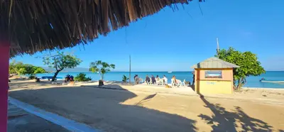 a beach with a building and people on the beach at Villa Rosa in Punta Rucia