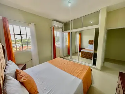 a bedroom with a bed and a large mirror at Balcón Skyline 2 in Jarabacoa