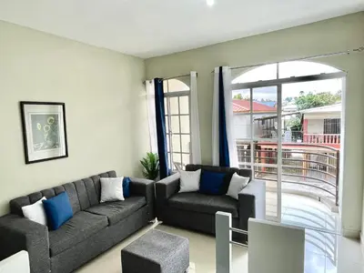 a living room with two couches and a large window at Balcón Skyline 2 in Jarabacoa