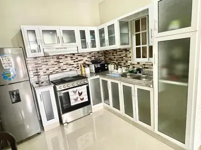 a kitchen with a stove and a refrigerator at Balcón Skyline 2 in Jarabacoa