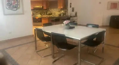 a kitchen with a white table and chairs at Escape 3BR Apartment Close to Downtown Mall in Bella Vista in Santo Domingo