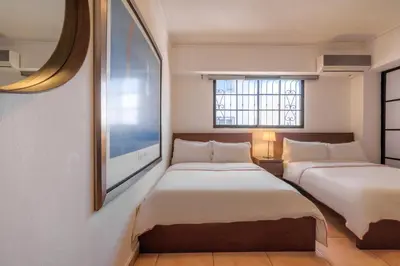 two beds in a room with a tv on the wall at Escape 3BR Apartment Close to Downtown Mall in Bella Vista in Santo Domingo