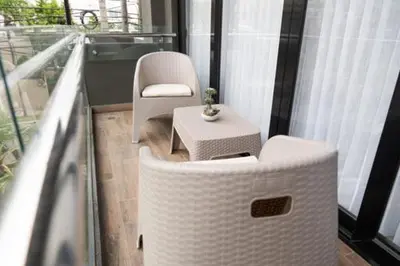 a balcony with two white chairs and a table at Luxurious and Spacious Condo in Santiago de los Caballeros