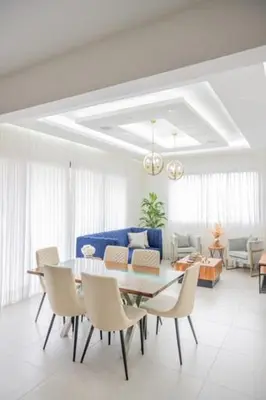 a living room with a dining room table and chairs at Luxurious and Spacious Condo in Santiago de los Caballeros
