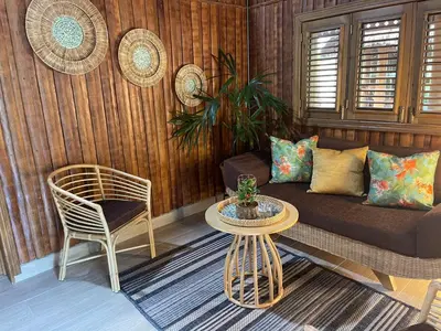a living room with a couch and a table and a chair at Hacienda La Huerta Puerto Plata, 1 BDR in San Felipe de Puerto Plata