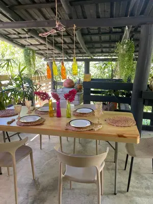a wooden table with plates and chairs on a patio at Hacienda La Huerta Puerto Plata, 2 BDR in Maimón