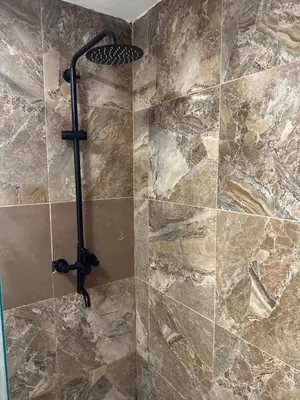 a shower in a bathroom with a stone wall at Noe Hotel One BedRoom #3 in Punta Cana