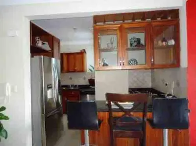 a kitchen with wooden cabinets and a stainless steel refrigerator at Self check in , moderno, A/C completo Wifi, TV 4K in Santiago de los Caballeros