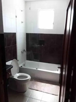 a bathroom with a toilet and a bath tub at Self check in , moderno, A/C completo Wifi, TV 4K in Santiago de los Caballeros