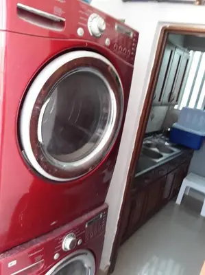 a red washing machine is sitting in a room at Self check in , moderno, A/C completo Wifi, TV 4K in Santiago de los Caballeros