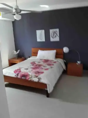 a bedroom with a bed with pink flowers on it at Self check in , moderno, A/C completo Wifi, TV 4K in Santiago de los Caballeros