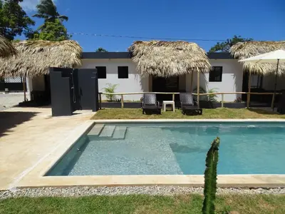 a swimming pool in front of a house at BUNGALOWS COLIBRI in Las Galeras