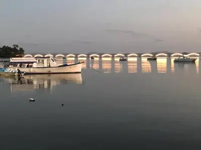 a boat in the water with a bridge in the background at Apart cercano al muelle y al malecón de Samana in Santa Bárbara de Samaná