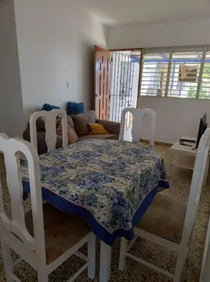 a dining room with a table and a couch at Apart cercano al muelle y al malecón de Samana in Santa Bárbara de Samaná