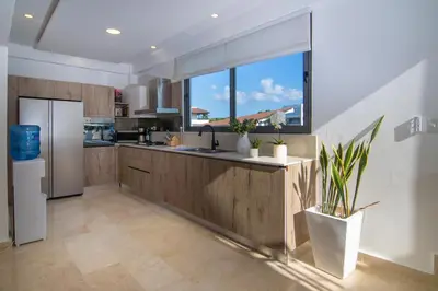 a kitchen with a refrigerator and a window at New Beachfront Penthouse Punta Popy in Las Terrenas