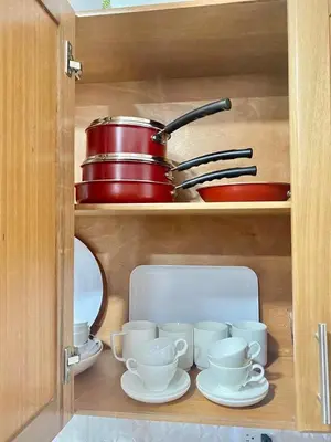 a cupboard filled with dishes and pots and pans at Super Luxurious L6 Sky Blue Apartment in Santo Domingo