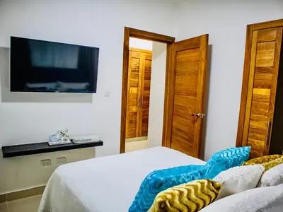 a bedroom with a bed and a flat screen tv at Super Luxurious L6 Sky Blue Apartment in Santo Domingo