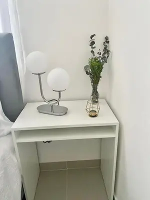 a white table with two lamps and flowers on it at Super Luxurious L6 Sky Blue Apartment in Santo Domingo