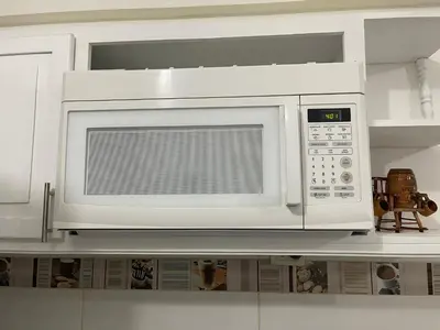 a white microwave oven above a kitchen counter at hospedaje de marant 2 in San Felipe de Puerto Plata