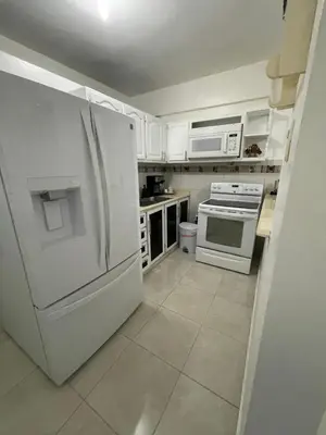 a white kitchen with a refrigerator and a stove at hospedaje de marant 2 in San Felipe de Puerto Plata