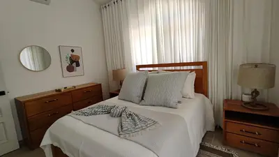 a bedroom with a bed with white sheets and a window at Luxury 4-Bedroom Villa with Climate Pool in Sosúa