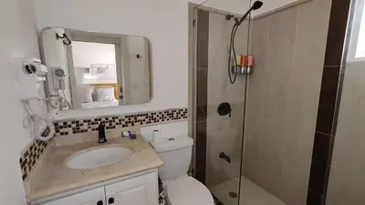 a bathroom with a toilet and a sink and a shower at Luxury 4-Bedroom Villa with Climate Pool in Sosúa