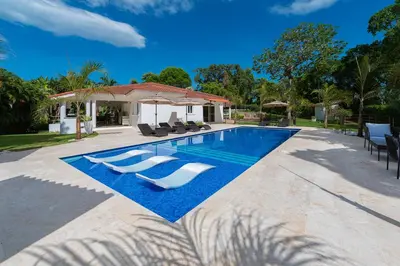 a swimming pool with lounge chairs and a house at Luxury 4-Bedroom Villa with Climate Pool in Sosúa