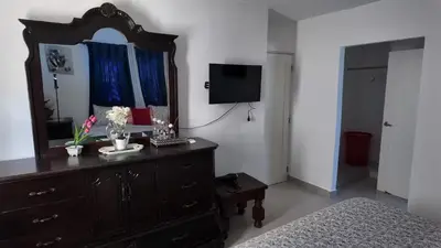 a bedroom with a dresser with a mirror and a bed at Residencial selene V, Family Modern Apartment w Pool & Near the beach in Punta Cana