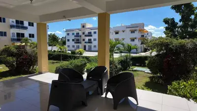a patio with chairs and a view of a building at Residencial selene V, Family Modern Apartment w Pool & Near the beach in Punta Cana
