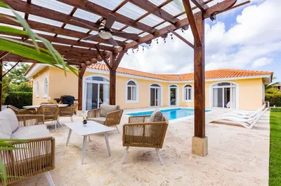 a patio with a table and chairs and a pool at Sosua Ocean Village Properties by Calisto Stays in Sosúa