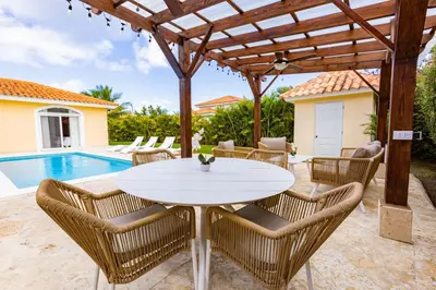 a patio with a white table and chairs and a pool at Sosua Ocean Village Properties by Calisto Stays in Sosúa