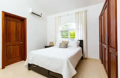 a white bedroom with a bed and a window at Sosua Ocean Village Properties by Calisto Stays in Sosúa