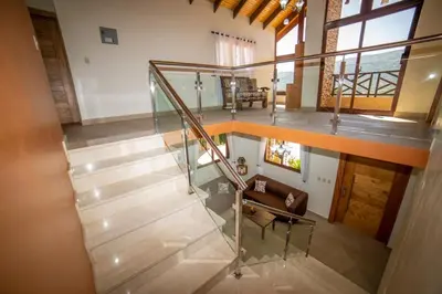 a staircase with a glass railing in a house at ωιℓℓу'ѕ νιℓℓα in Jarabacoa