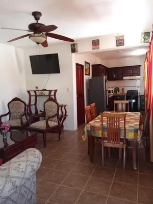 a living room with a table and chairs and a kitchen at Apartamentos ipap luperon in Puerto de Luperon