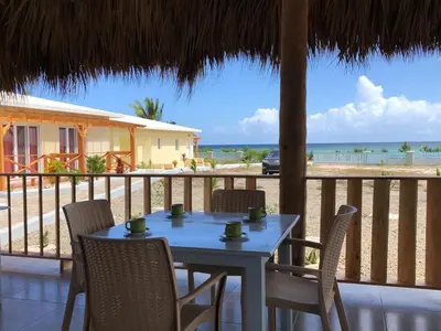 a table and chairs on a balcony with the beach at Punta Rucia Cristal Beach in Punta Rucia