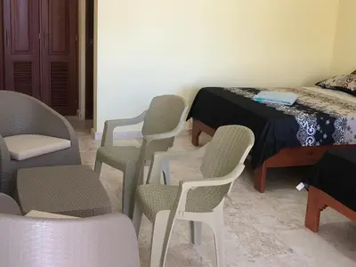 a room with chairs and a table and a bed at Punta Rucia Cristal Beach in Punta Rucia