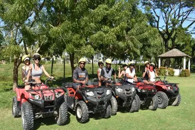 a group of people sitting on atvs in a field at Peace By The River in Jarabacoa