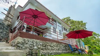 two red umbrellas sitting in front of a building at Peace By The River in Jarabacoa
