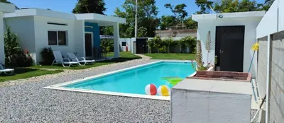 a villa with a swimming pool in front of a house at Casa merengue in Las Terrenas