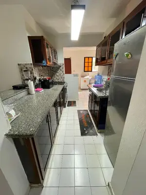 a kitchen with a stainless steel refrigerator and white tile floors at Casa Corona Plaza in Santiago de los Caballeros