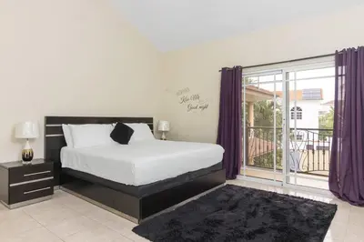 a bedroom with a bed and a balcony at Super Spacious 4BR 4 5BA Villa w pool in Sosua in Sosúa
