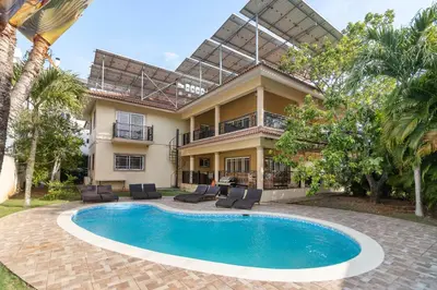 a villa with a swimming pool in front of a house at Super Spacious 4BR 4 5BA Villa w pool in Sosua in Sosúa