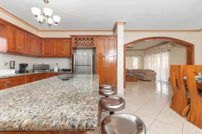 a kitchen with a counter and stools in it at Super Spacious 4BR 4 5BA Villa w pool in Sosua in Sosúa