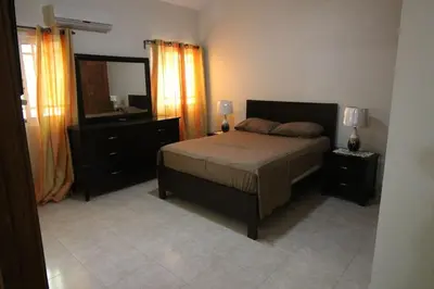 a bedroom with a bed and a dresser and a mirror at Super Spacious 4BR 4 5BA Villa w pool in Sosua in Sosúa