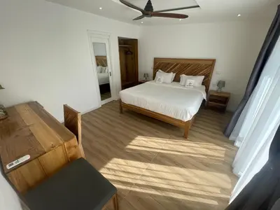 a bedroom with a bed and a ceiling fan at Hotel El Quemaito - Luxury Oceanfront Retreat in Santa Cruz de Barahona