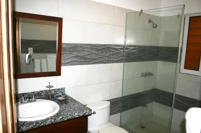 a bathroom with a sink and a glass shower at Costambar Tropical Garden in San Felipe de Puerto Plata